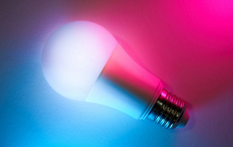 smart LED bulb on a blue to pink gradient backround